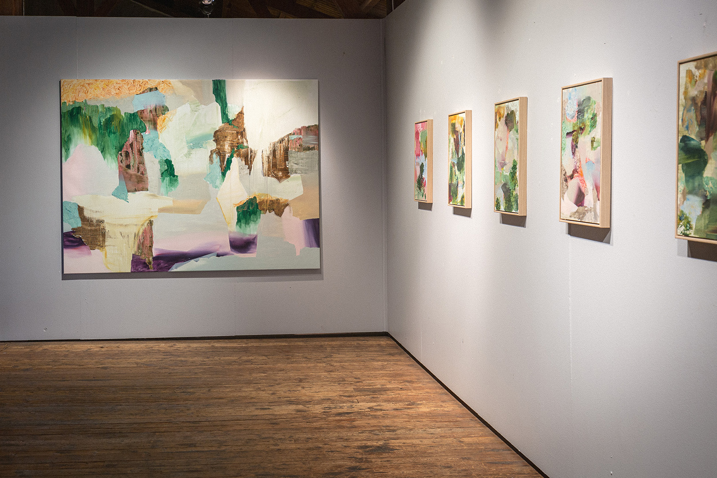 Photo of the artist and three paintings from NP33 exhibition